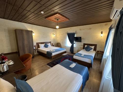 a hotel room with two beds and a table at Virtus Cappadocia Hotel Göreme in Goreme
