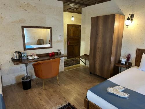 a bedroom with a bed and a desk with a mirror at Virtus Cappadocia Hotel Göreme in Goreme