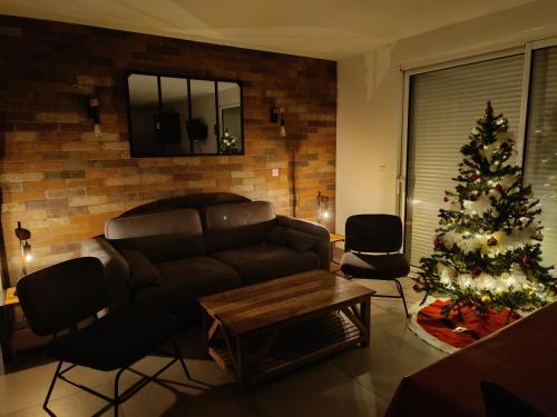 a living room with a christmas tree and a couch at Le Repos du Randonneur in Audinghen