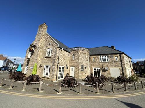 a large brick building with a clock tower on it at Bliss On The Bay in Filey