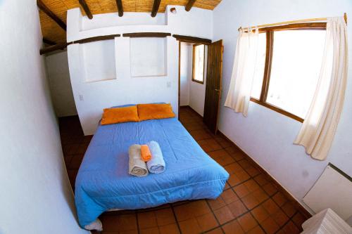 ein kleines Schlafzimmer mit einem blauen Bett in einem Zimmer in der Unterkunft La Casa de Violeta in Tilcara