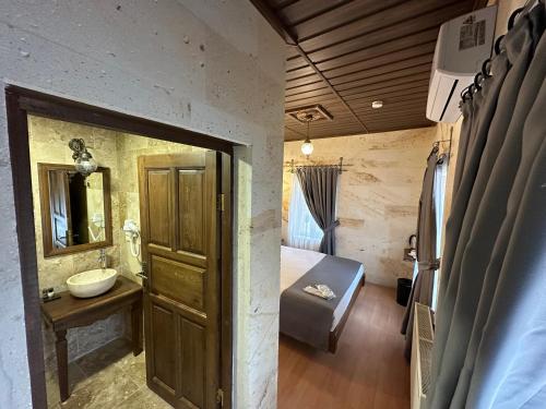 a bedroom with a bed and a sink and a mirror at Virtus Cappadocia Hotel Göreme in Goreme