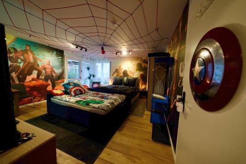 Habitación con cama y pintura en la pared en EDLER WOHNRAUM Disney Marvel Studio mit Boxspringbett, Netflix, Einbaukaffeevollautomat, Terrasse & Lift, en Chemnitz