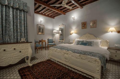 um quarto com uma grande cama branca e uma mesa em Cavalry Villa bikaner em Bikaner