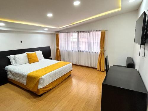 een slaapkamer met een bed en een flatscreen-tv bij Hostal Habitaciones de la 39 in Pasto