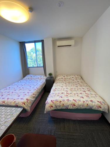 a bedroom with two beds and a window at MR TOMO FUJI in Fuji