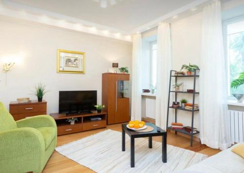 sala de estar con TV, sofá y mesa en VIP apart 741, en Tiflis