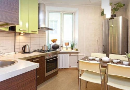 una cocina con armarios verdes, mesa y sillas en VIP apart 741, en Tiflis