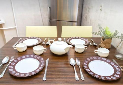 a wooden table with plates and utensils on it at VIP apart 741 in Tbilisi City