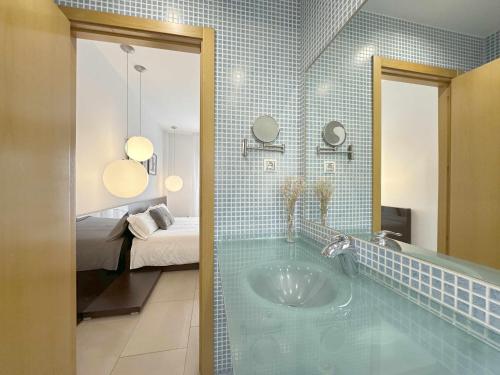 a bathroom with a tub with a bed and a mirror at Casa Jimena in Avila