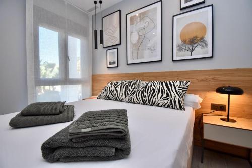 a bedroom with a large white bed with towels on it at Villa Cactae in Novo Sancti Petri