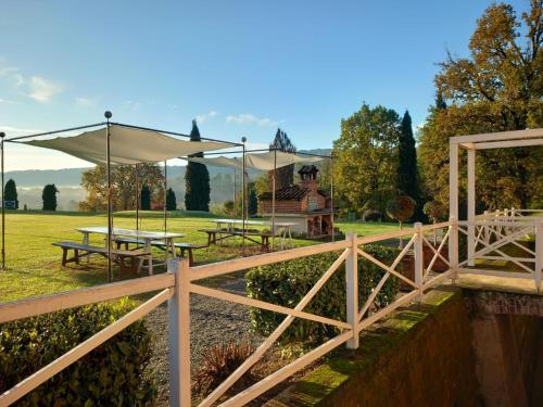 a fence with tables and umbrellas in a field at Tenuta Castello in Cerrione