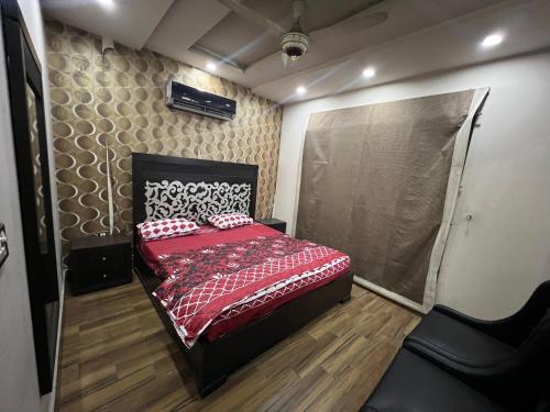 a bedroom with a bed with a red comforter at Prime Plaza in Gujrānwāla