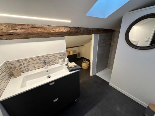 a bathroom with a sink and a mirror at La maison du village in Romanèche-Thorins