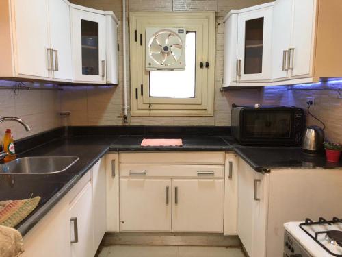 a kitchen with a sink and a clock on the wall at Luxury apartment in Mohandiseen in Cairo