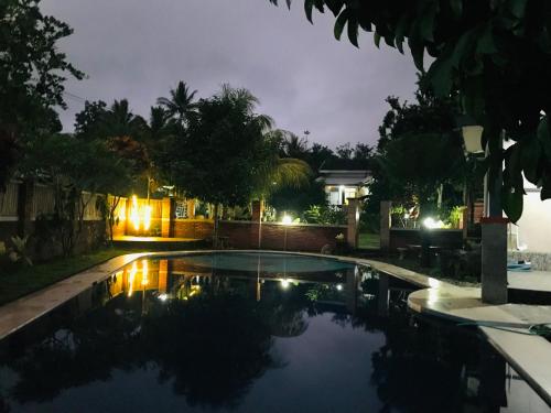 a swimming pool in a yard at night at Bello Bungalow in Batukliang