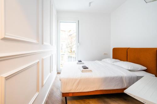 een slaapkamer met een bed en een raam bij City Center Design Apartments in Sarajevo