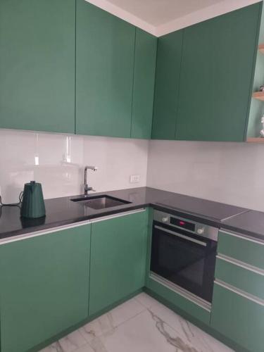 a kitchen with green cabinets and a sink at Appartamento centro Sondrio in Sondrio