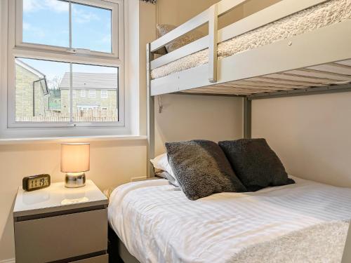 a bedroom with a bed and a bunk bed at Crawshaw Cottage in Buxton