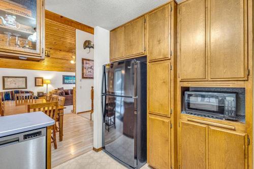 a kitchen with a refrigerator and a dining room at Big Leaf - Unit 6 in Sunriver