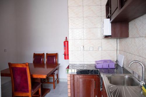a kitchen with a sink and a table with chairs at B I G Residence Hotel in Bujumbura