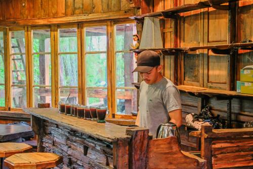 a man standing in a kitchen in a room at Omah kayu bromo in Ngadisari