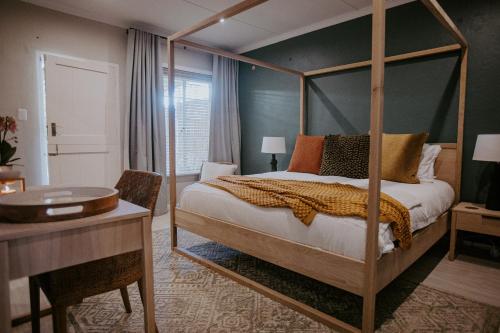 a bedroom with a four poster bed and a desk at Lavender BnB in East London