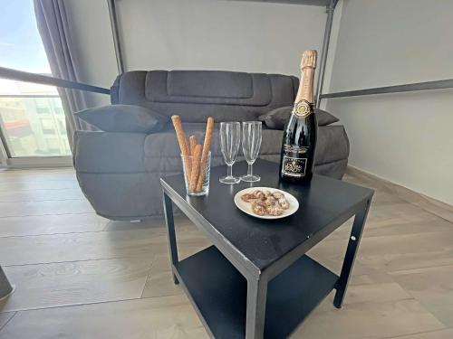 - une table avec une bouteille de champagne et des verres à vin dans l'établissement Studio 23m² avec Parking Privé, Ascenseur, Proche Mer - Berck - FR-1-646-19, à Berck-sur-Mer