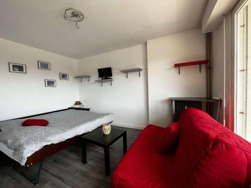 - une chambre avec un lit et un canapé rouge dans l'établissement Studio Proche Plage et Commerces - Balcon Sud, Parking Privatif, Résidence Sécurisée - FR-1-646-23, à Berck-sur-Mer