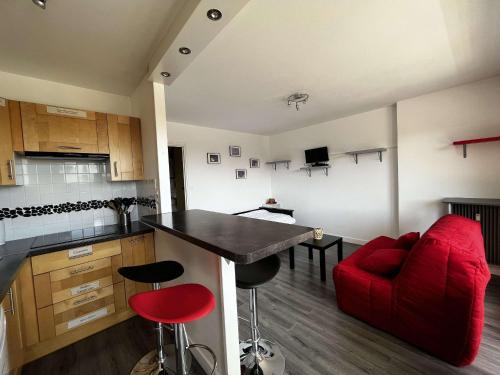 une cuisine avec un canapé rouge et un fauteuil rouge dans l'établissement Studio Proche Plage et Commerces - Balcon Sud, Parking Privatif, Résidence Sécurisée - FR-1-646-23, à Berck-sur-Mer