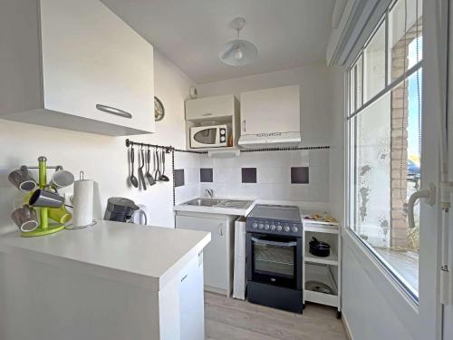 kuchnia z białymi urządzeniami i dużym oknem w obiekcie Studio Pieds dans l'Eau, Moderne et Équipé - Rez-de-Chaussée - FR-1-646-25 w mieście Berck-sur-Mer