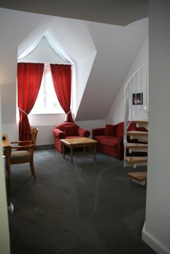 a living room with a red couch and a window at Das Goldene Lamm Aalen in Aalen