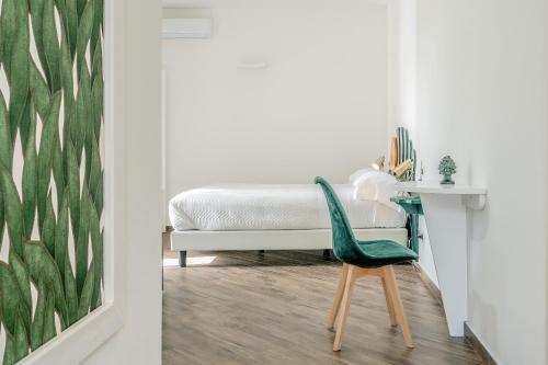 a bedroom with a bed and a green chair at Agriturismo Nonno Luigino in Vico Equense