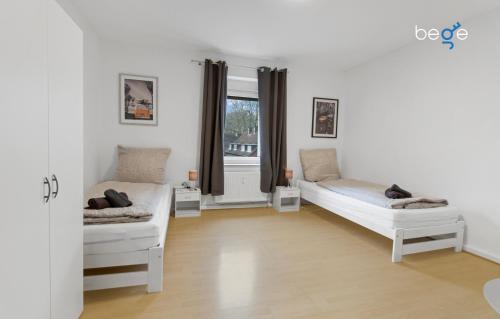 a bedroom with two beds and a window at BEGE APARTMENTS: WORKSPOT in Gelsenkirchen