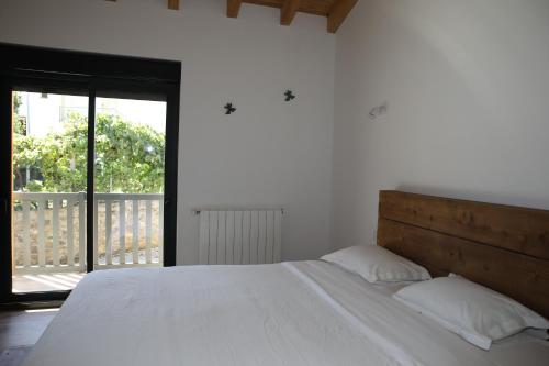 a bedroom with a large white bed and a balcony at Casa da Teresinha in Bragança