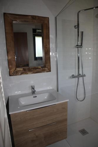 a bathroom with a sink and a shower with a mirror at Casa da Teresinha in Bragança