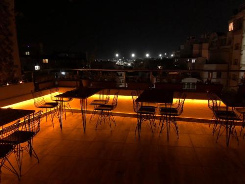 MARDİA CİTY OTEL في إسطنبول: مجموعة من الطاولات والكراسي على السطح في الليل