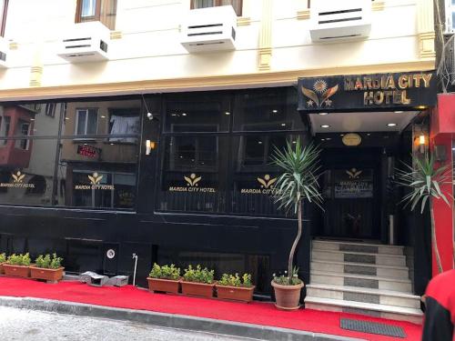 um restaurante com vasos de plantas em frente a um edifício em MARDİA CİTY OTEL em Istambul