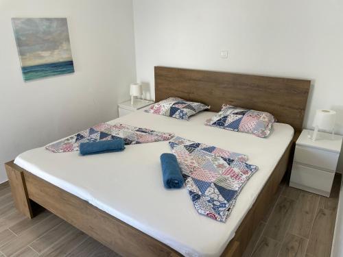 two beds in a bedroom with two blue pillows at Apartmani Hržan-Keglević in Mandre