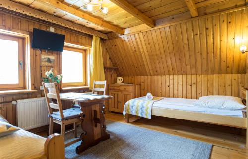 a bedroom with a bed and a desk in a room at Ania Wynajem Pokoi in Zakopane