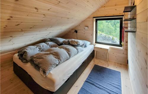 uma cama num chalé de madeira com uma janela em Gorgeous Home In Jsenfjorden With Sauna em Gullingen