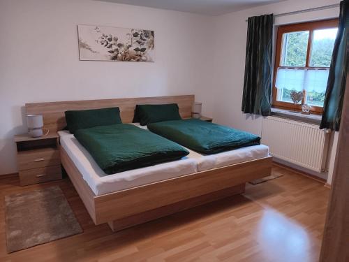 a bedroom with a bed with green sheets and a window at Ferienwohnung Butterfly in Lam