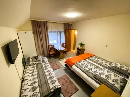 a hotel room with two beds and a tv at Ośrodek Wczasowo-Kolonijny Groń in Biały Dunajec