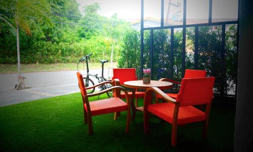 a table and chairs sitting in a room with a window at Cool Residence Hotel in Phuket Town