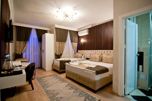 a hotel room with two beds and a couch at Hotel Broken Column in Istanbul