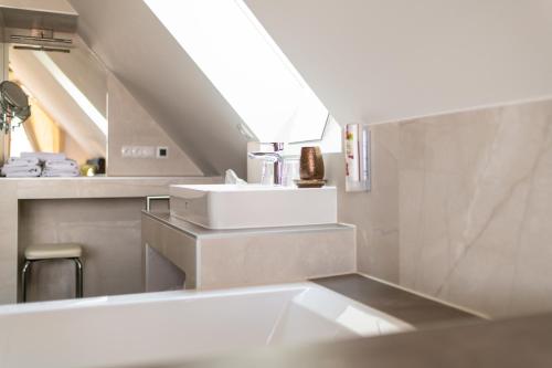 a bathroom with a sink and a mirror at Sattlerhof Genießerhotel & Weingut in Gamlitz