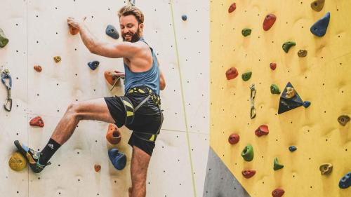 a man is on a climbing wall at Sporthotel Zoll in Vipiteno