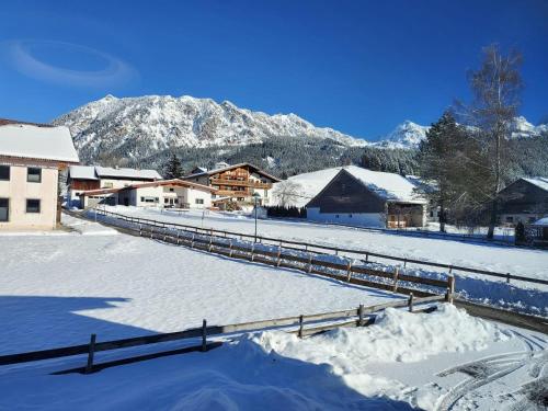 a snow covered village with mountains in the background at Rosa's Ferienhaus Ferienwohnung Rote Flueh in Grän