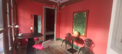 a red wall with two tables and chairs in a room at Casa Artistica 2 in Gandía
