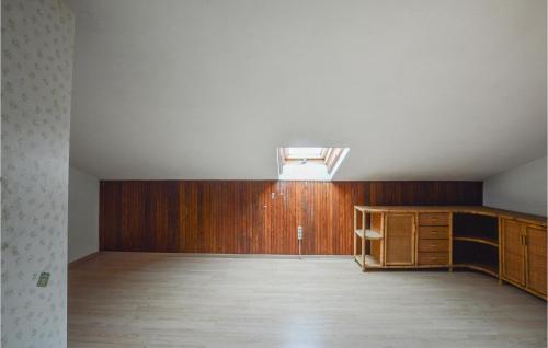 een lege kamer met houten lambrisering en een dakraam bij Nice Home In Castelnuovo Bormida With Kitchen in Castelnuovo Bormida